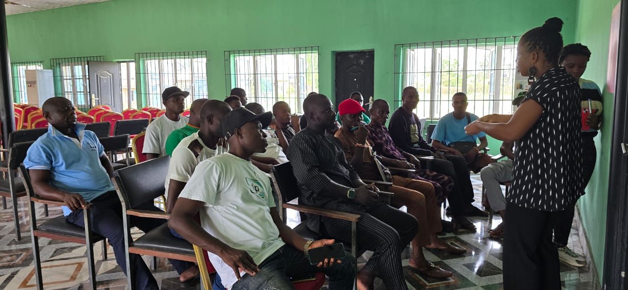 Kortch team briefing community members and youth indoors